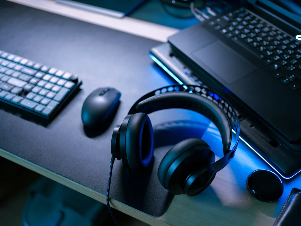 Gaming laptop with a headset, keyboard and mouse on a desk